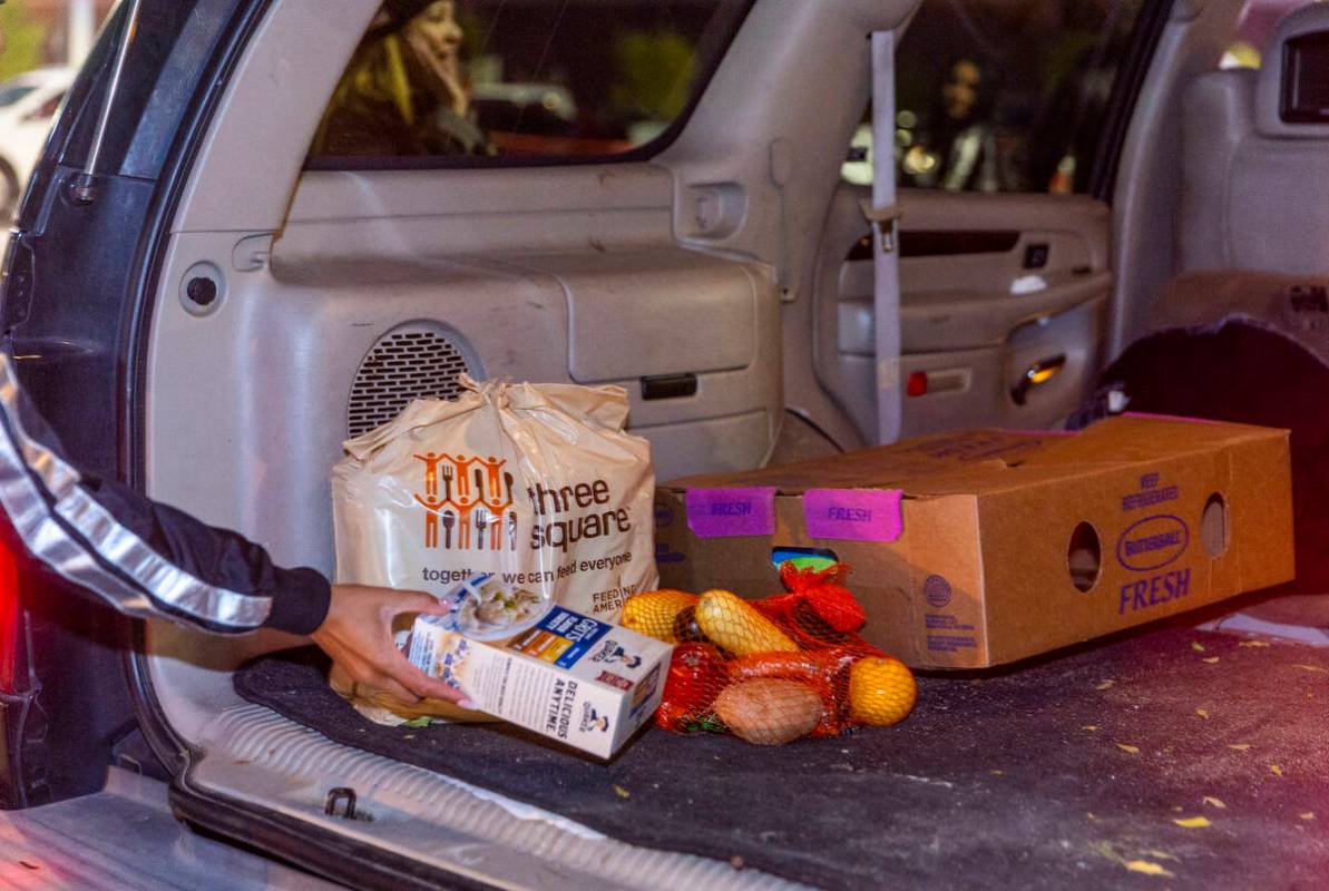 A complete meal is placed in a vehicle as Raiders' current and former players with staff take p ...