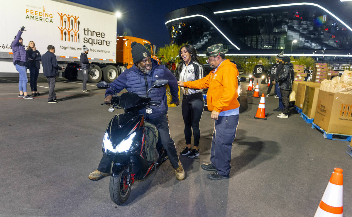 (LtoR) Terrence Hazel receives the last of his food from Raiderette Cierra and Angel Marrero wi ...