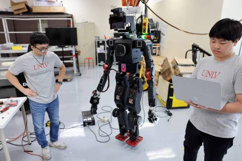 UNLV mechanical engineering students Truc Tran, left, and Baekseok Kim with a robot in their la ...