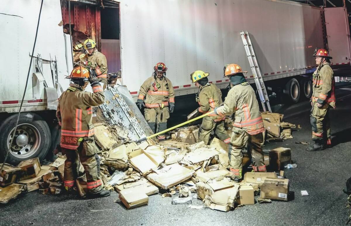 Firefighters work at the scene of a crash in the southbound lanes of -15 north of downtown Las ...
