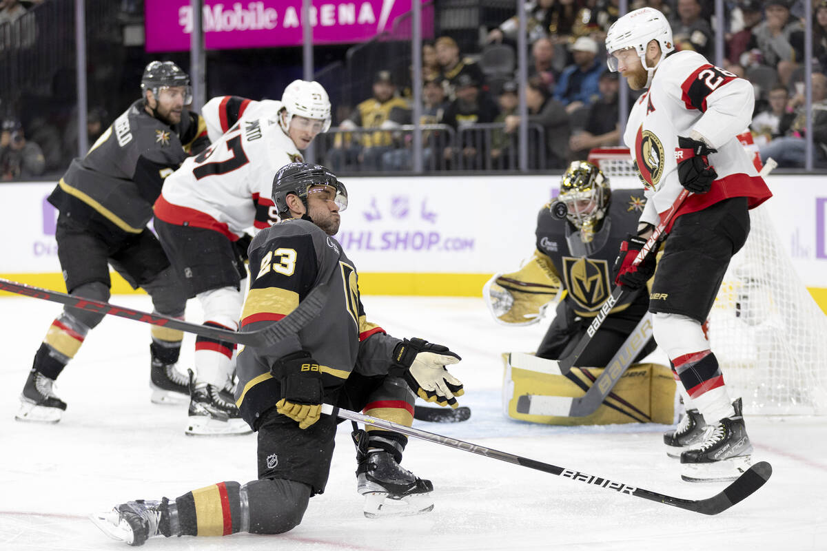 Golden Knights defenseman Alec Martinez (23) dives for the puck while goaltender Logan Thompson ...