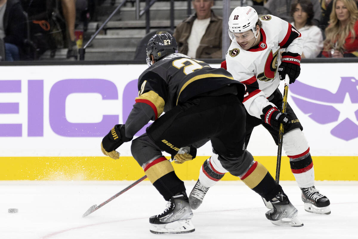 Golden Knights defenseman Shea Theodore (27) steals the puck from Senators right wing Alex DeBr ...