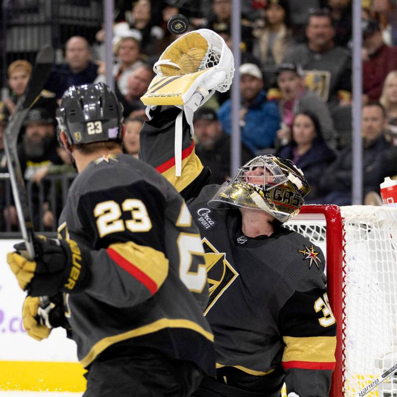 Golden Knights goaltender Logan Thompson (36) makes a glove save while defenseman Alec Martinez ...