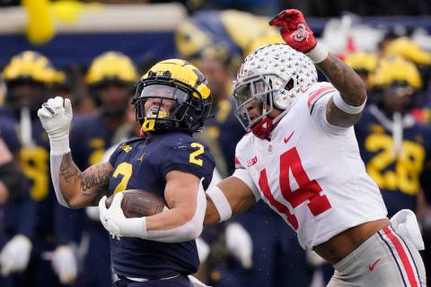 FILE - Michigan running back Blake Corum (2) is chased by Ohio State safety Ronnie Hickman duri ...