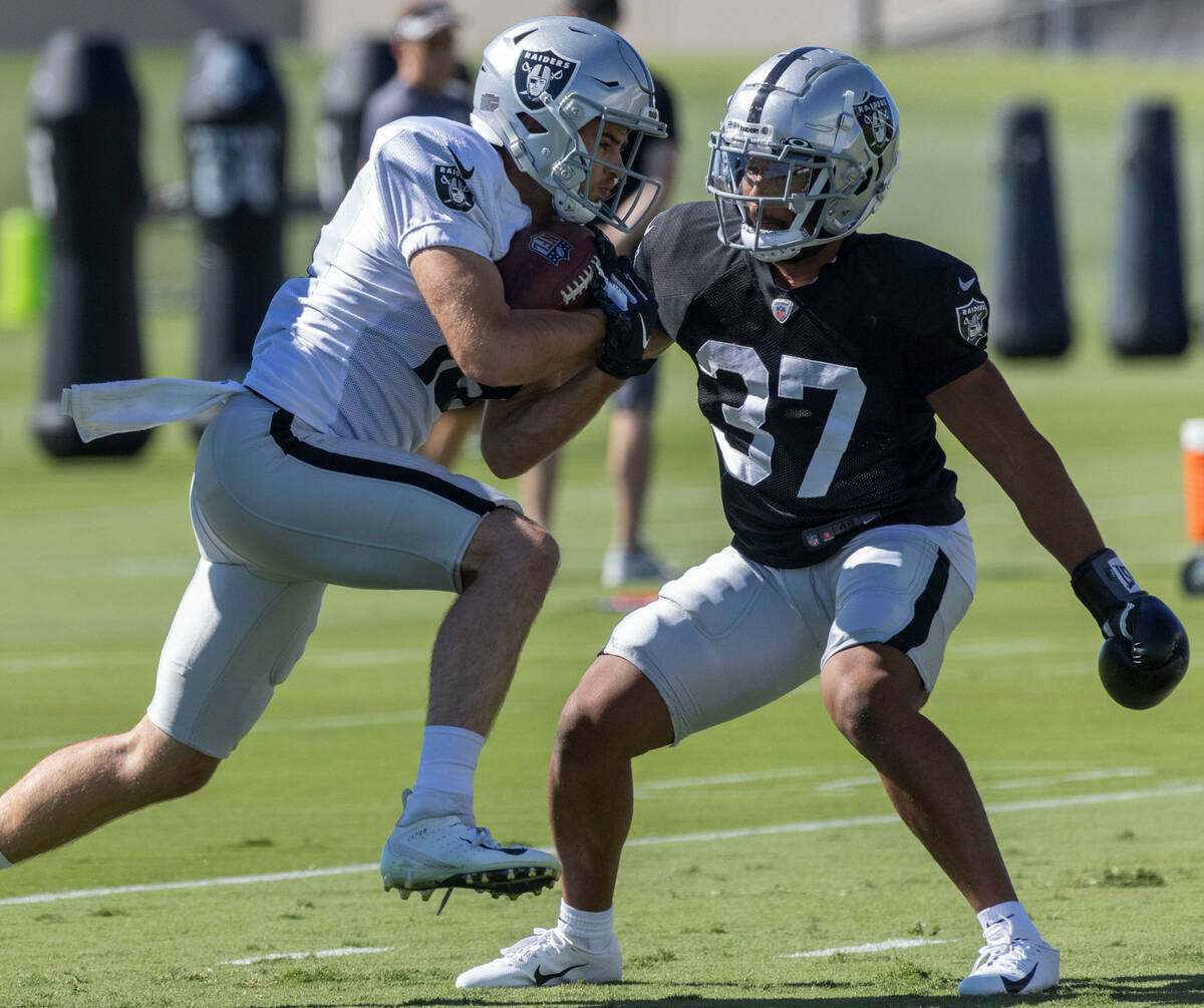 Raiders wide receiver Hunter Renfrow (13) holds on to the football as cornerback Tyler Hall (37 ...