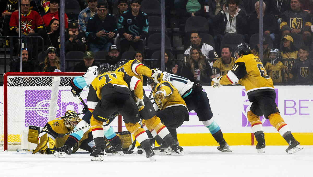 Golden Knights goaltender Adin Hill (33) eyes the puck amongst teammates as Seattle Kraken righ ...