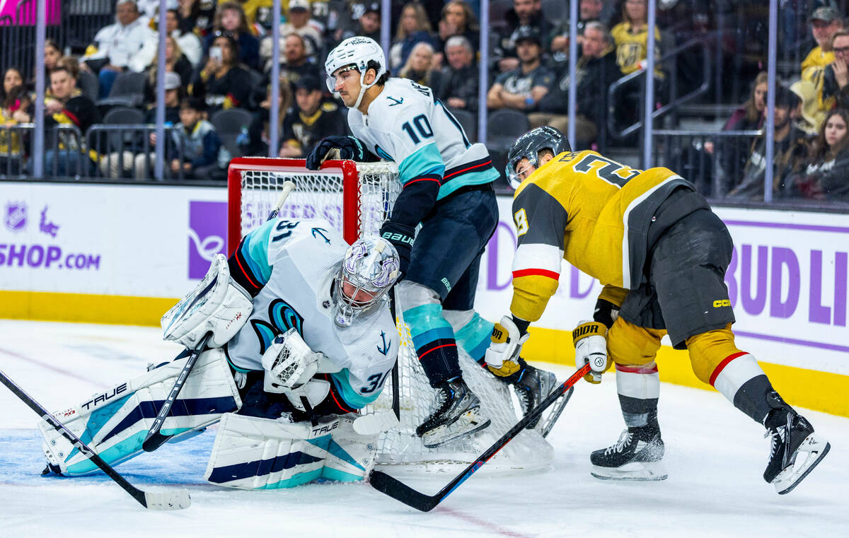 Seattle Kraken goaltender Philipp Grubauer (31) secures a puck in his glove with teammate cente ...