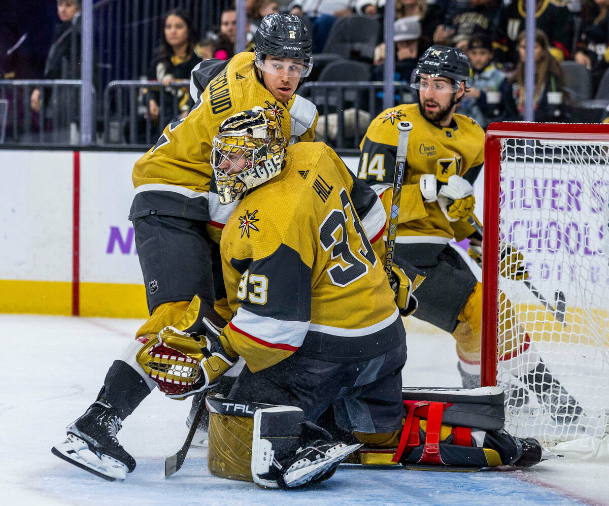 Golden Knights goaltender Adin Hill (33) protects the net with teammates defenseman Zach Whitec ...