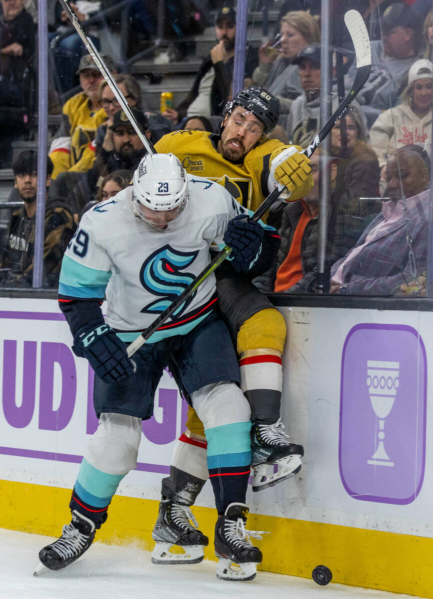 Seattle Kraken defenseman Vince Dunn (29) checks Golden Knights center Chandler Stephenson (20) ...