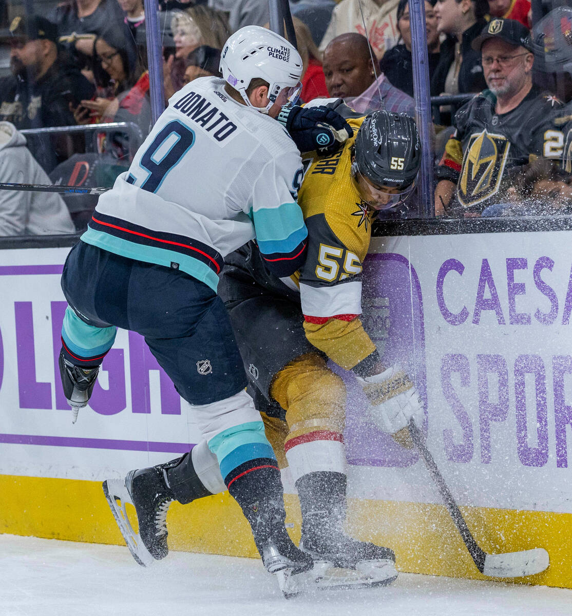 Seattle Kraken center Ryan Donato (9) drives Golden Knights right wing Keegan Kolesar (55) into ...