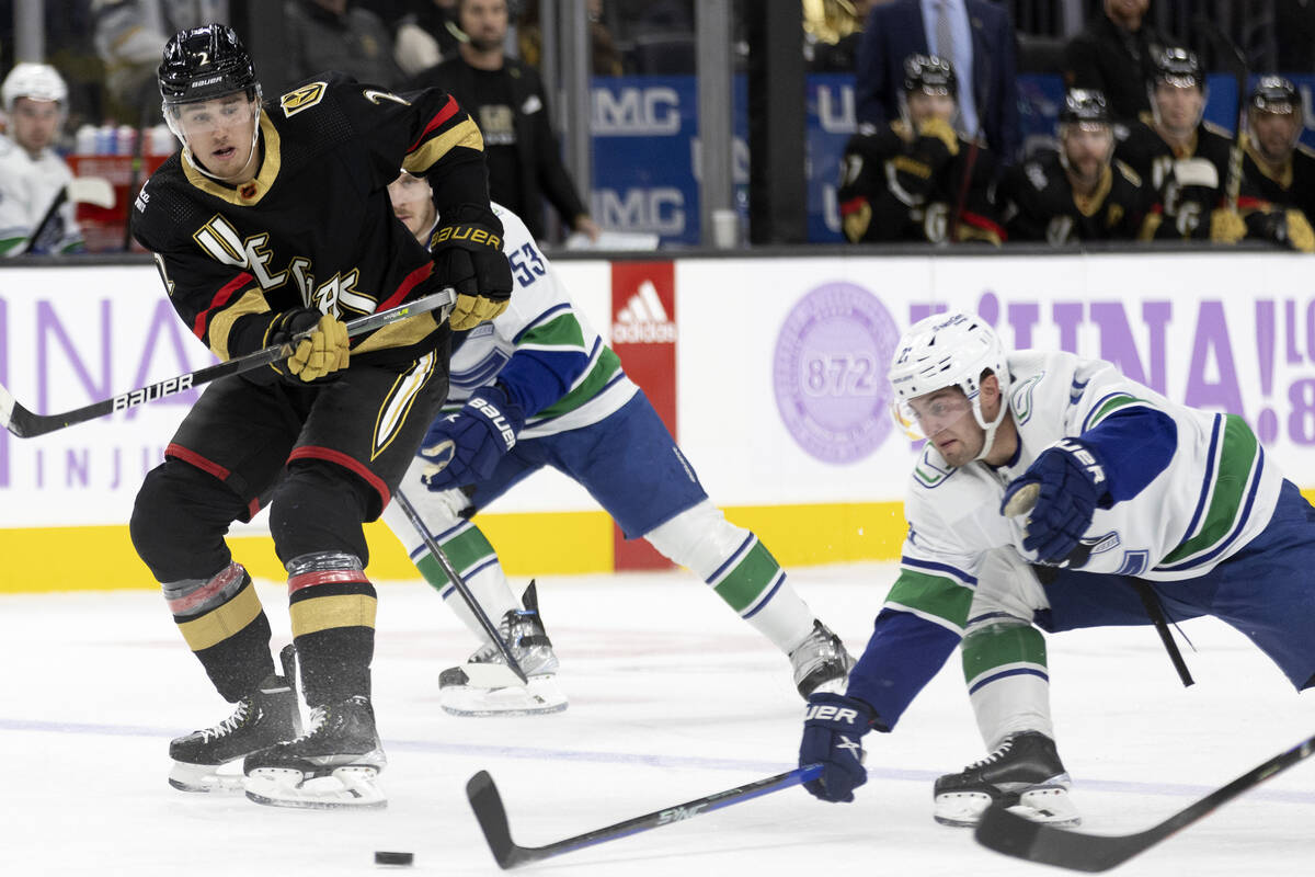 Golden Knights defenseman Zach Whitecloud (2) passes while Canucks left wing Nils Hoglander (21 ...