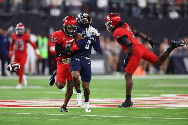 Nevada Wolf Pack wide receiver Jamaal Bell (3) makes a catch under pressure from UNLV Rebels de ...