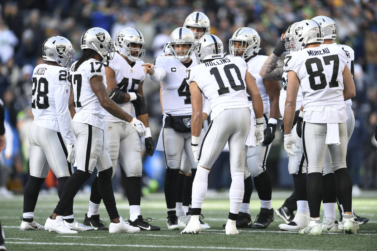 Las Vegas Raiders quarterback Derek Carr (4) directs teammates in the huddle during the first h ...
