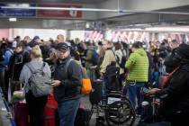 Travelers walk through terminal 1 at Harry Reid International Airport on Sunday, Nov. 27, 2022, ...