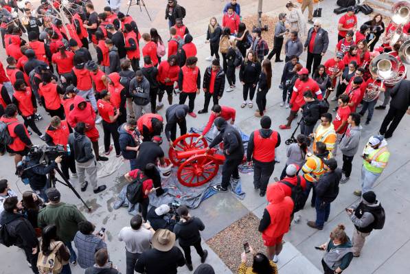 UNLV Football players and students paint the Fremont Cannon red during a celebration on campus ...