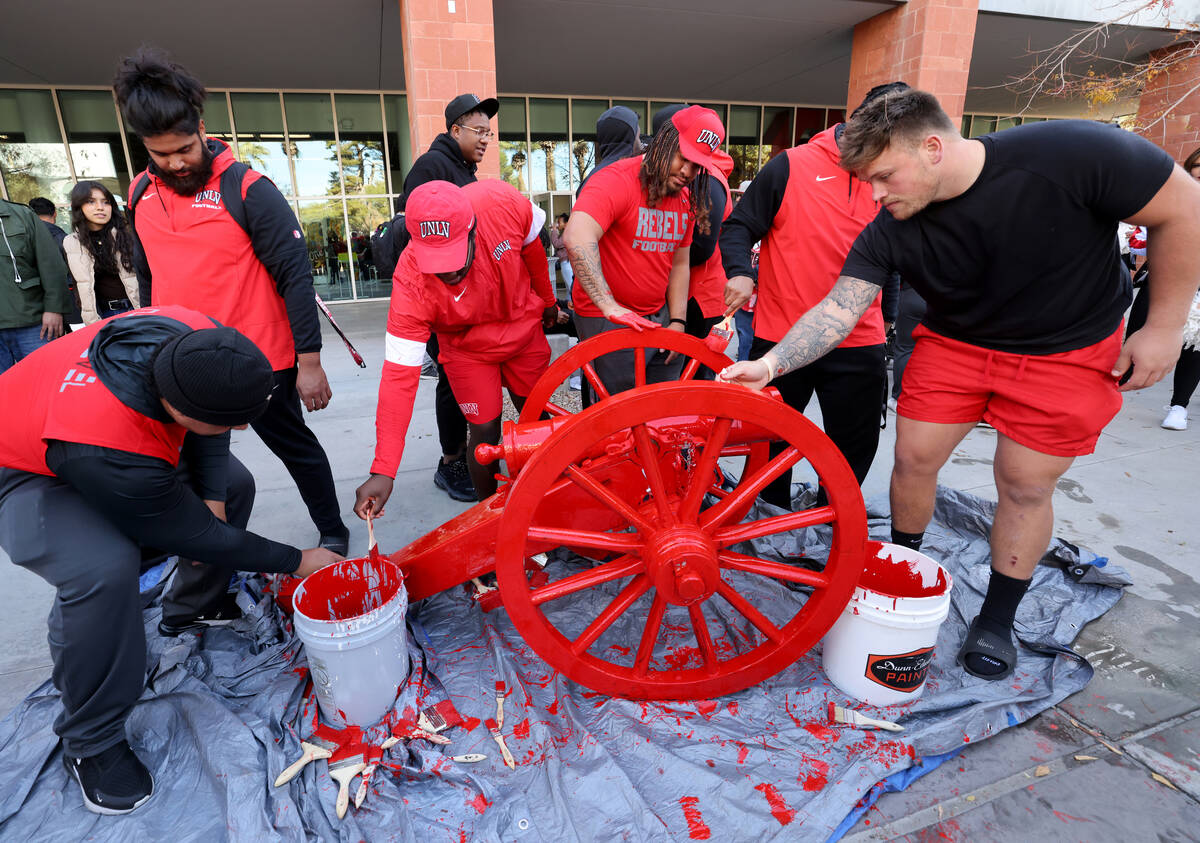 UNLV Football players paint the Fremont Cannon red during a celebration on campus Monday, Nov. ...
