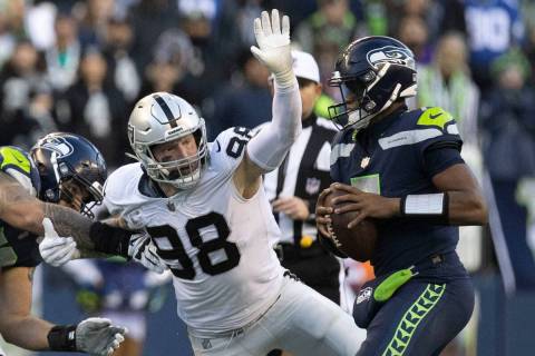 Raiders defensive end Maxx Crosby (98) looks to defend a pass from Seattle Seahawks quarterback ...