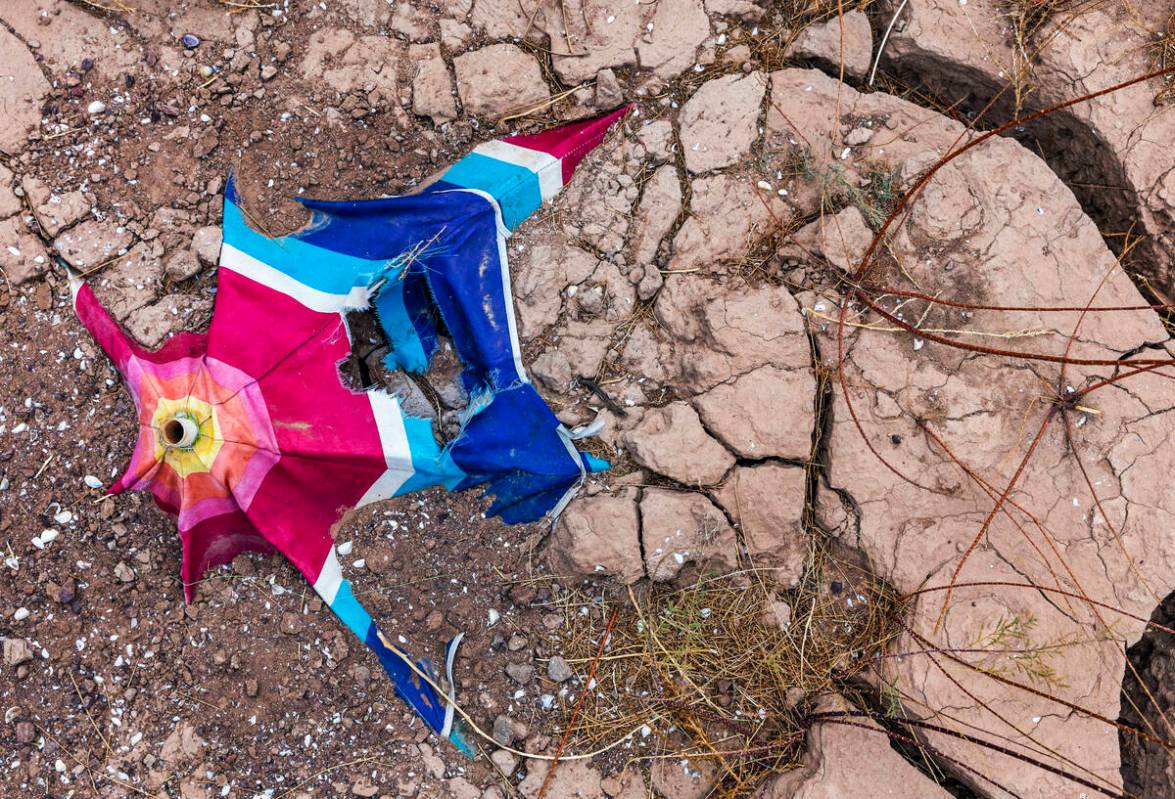 An old umbrella breaks down remaining in dried mud as the water level continues to recede at th ...
