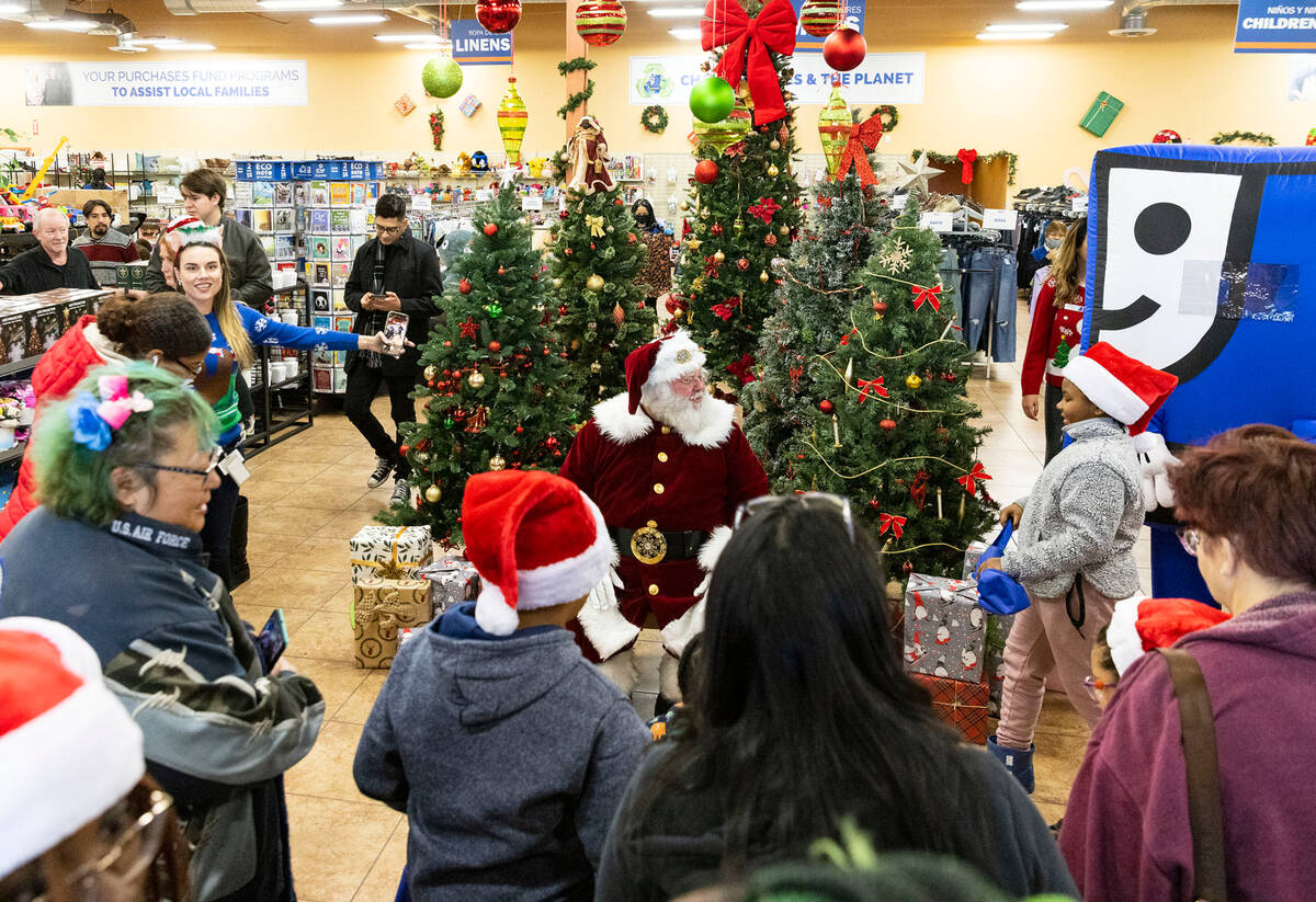 Shoppers wait in line to pose for a photo with Santa Claus at Goodwill Thrift Store, on Friday ...