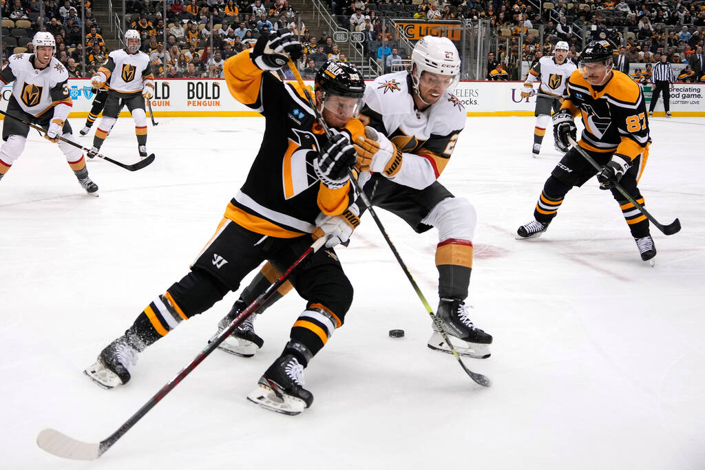 Vegas Golden Knights' Shea Theodore (27) ties up Pittsburgh Penguins' Jake Guentzel (59) during ...