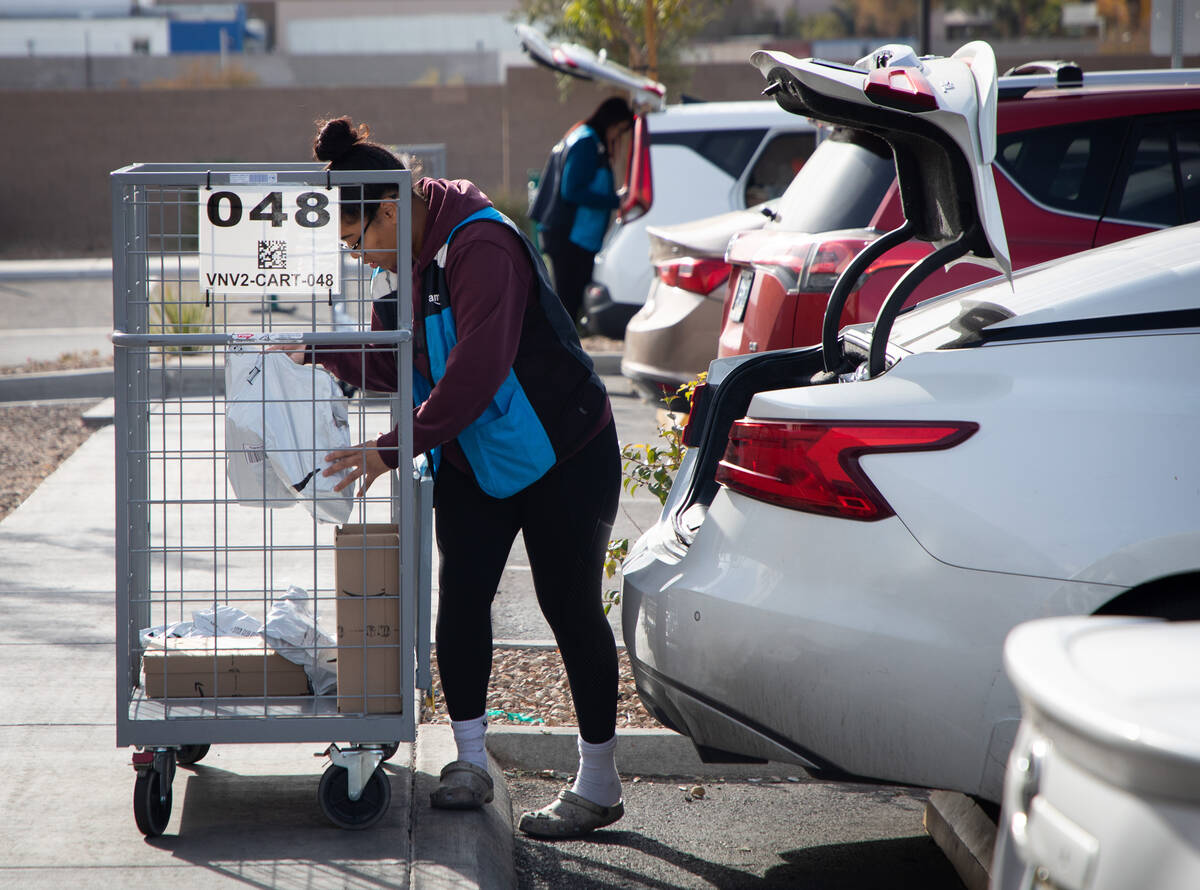 Aalaya McQuaig, Amazon Flex driver, loads packages into her car outside of Amazon's SNV1 facili ...