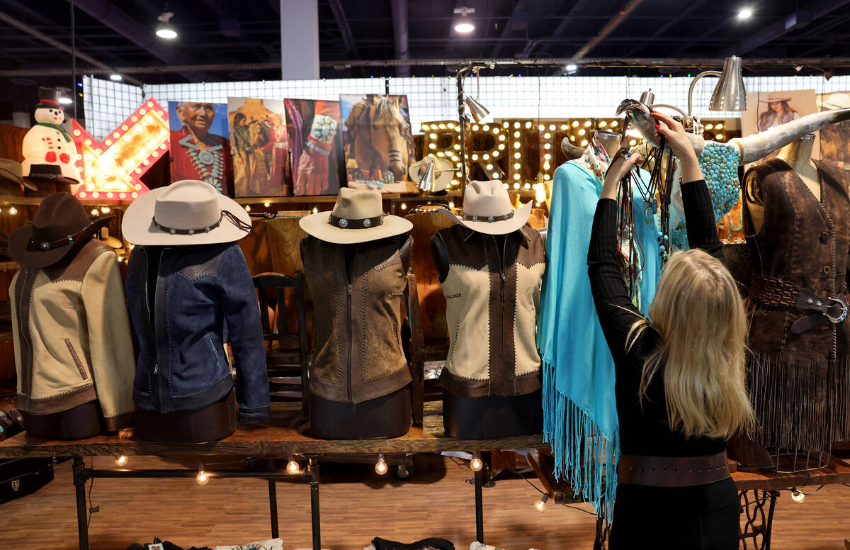 Kathleen Wojtasiak prepares merchandise at the Brit West booth during Cowboy Christmas at the L ...