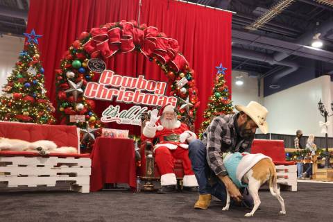 Dan Vega of Las Vegas prepares his dog “Jeffrey” at the Santa photo booth during ...