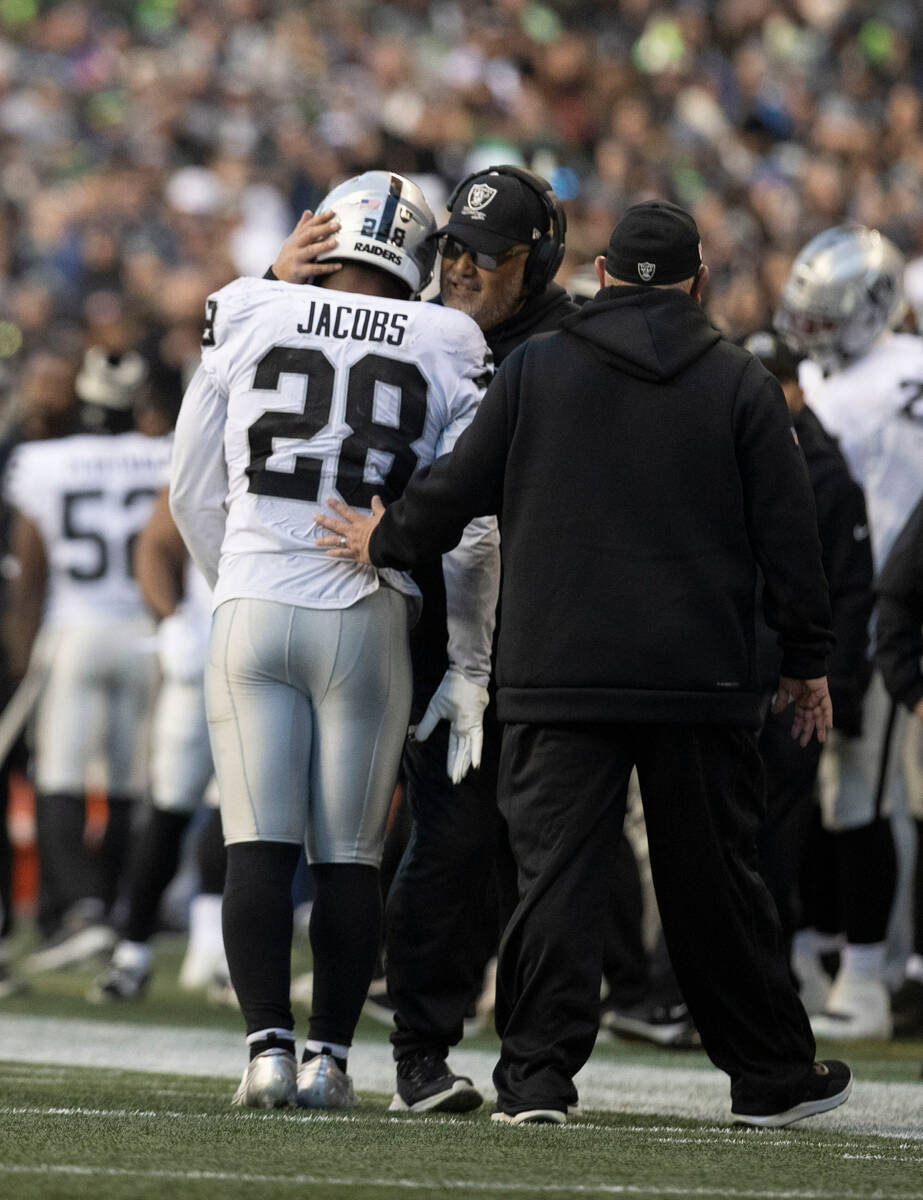 Raiders running back Josh Jacobs (28) is consoled by coach Kennedy Polamalu as he exits the gam ...