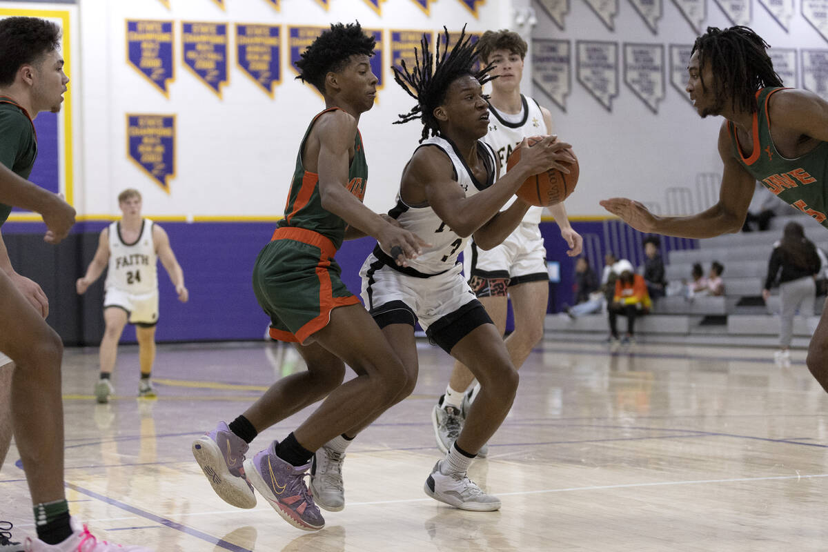 Faith Lutheran’s JohnPaul Agu (3) shoots between Mojave’s Zaccarion Jackson, cent ...