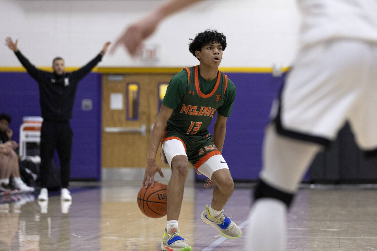 Mojave’s Nathan Sherrard (13) dribbles before passing during a boys high school basketba ...