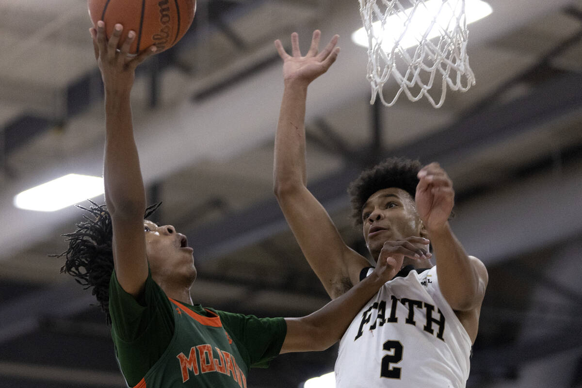 Mojave’s Giali Chapman (2) shoots against Faith Lutheran’s LJ Mercurius (2) duri ...