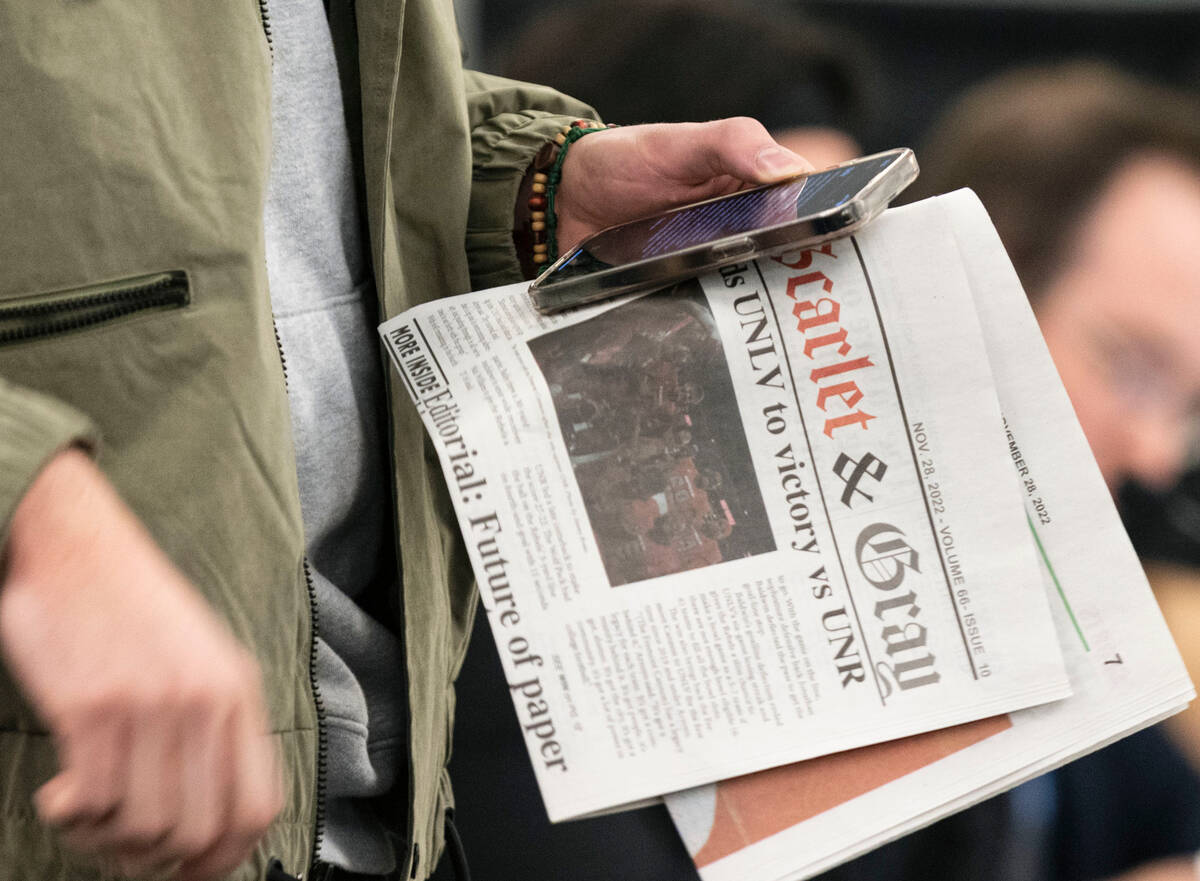 Jared Nixon, a UNLV student, holds a copy of The Scarlet & Gray Free Press newspaper as he prep ...
