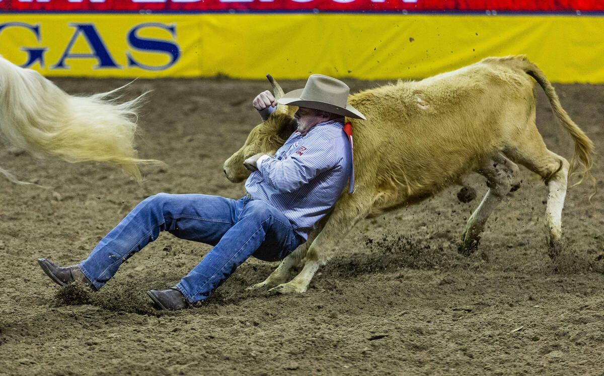 Hunter Cure of Holliday, TX., competes in Steer Wrestling on his winning round during the Natio ...