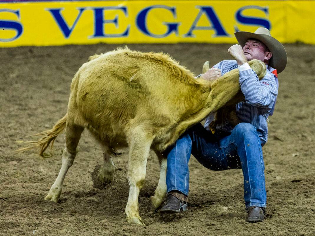 Hunter Cure of Holliday, TX., competes in Steer Wrestling on his winning round during the Natio ...