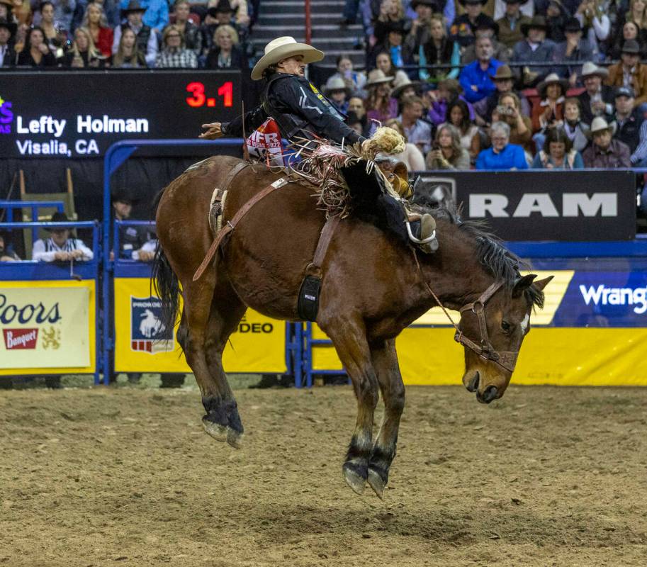 Lefty Holman of Visalia, CA., rides Wall Street to a winning score in Saddle Bronc Riding durin ...