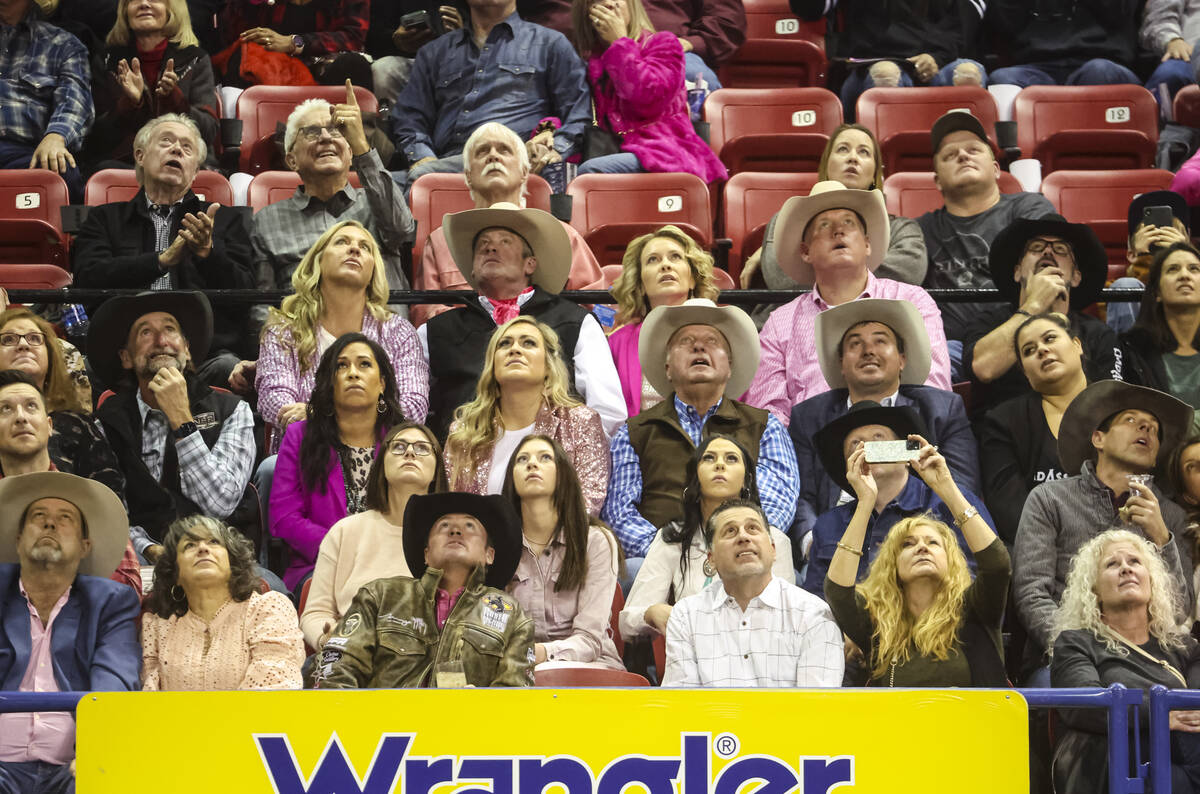 Attendees watch a replay during the fifth go-round of the National Finals Rodeo at the Thomas & ...