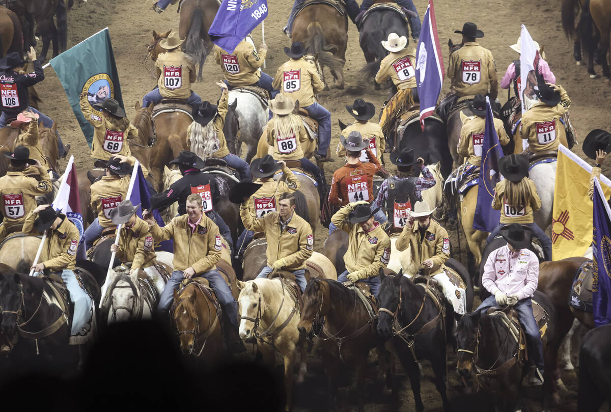 Competitors tip their hats to the crowd during the fifth go-round of the National Finals Rodeo ...