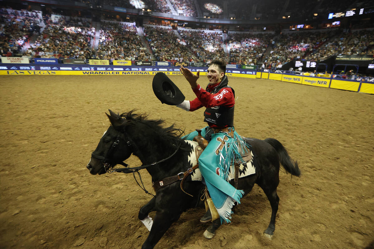 Jess Pope celebrates his round win in the bareback riding competition during the 64th Wrangler ...