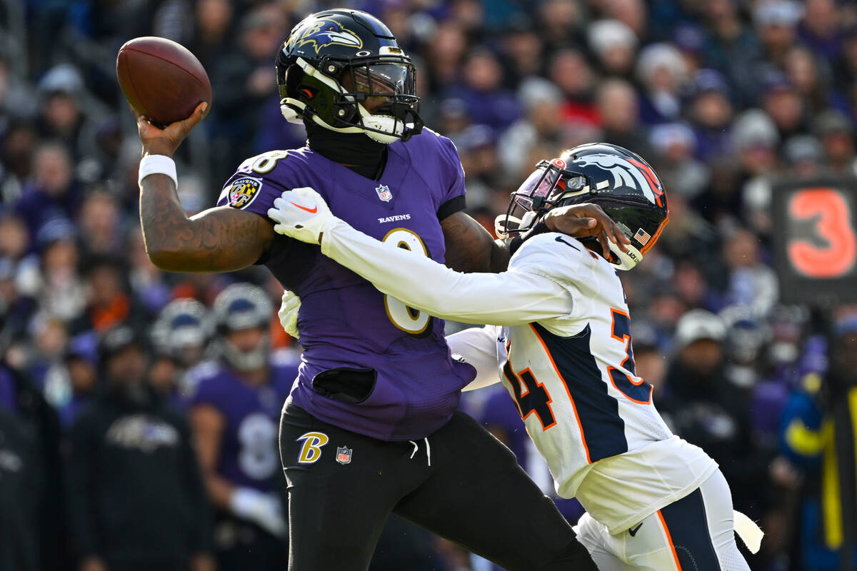 Baltimore Ravens quarterback Lamar Jackson (8) throws while being pressured by Denver Broncos c ...