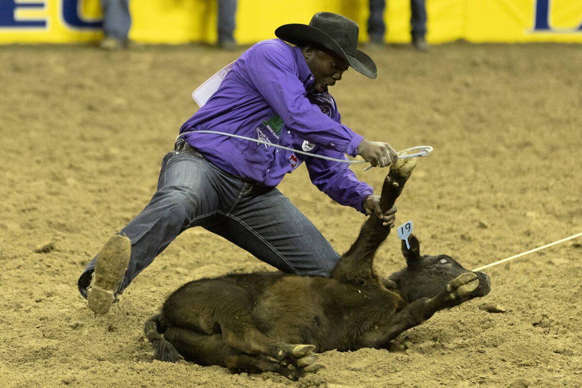 John Douch, of Huntsville, Tex., competes in tie-down roping during the sixth go-round of the N ...