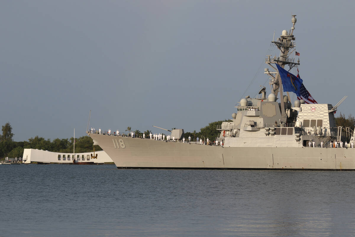 Sailors aboard the the USS Daniel Inouye render honors while passing the USS Arizona Memorial a ...