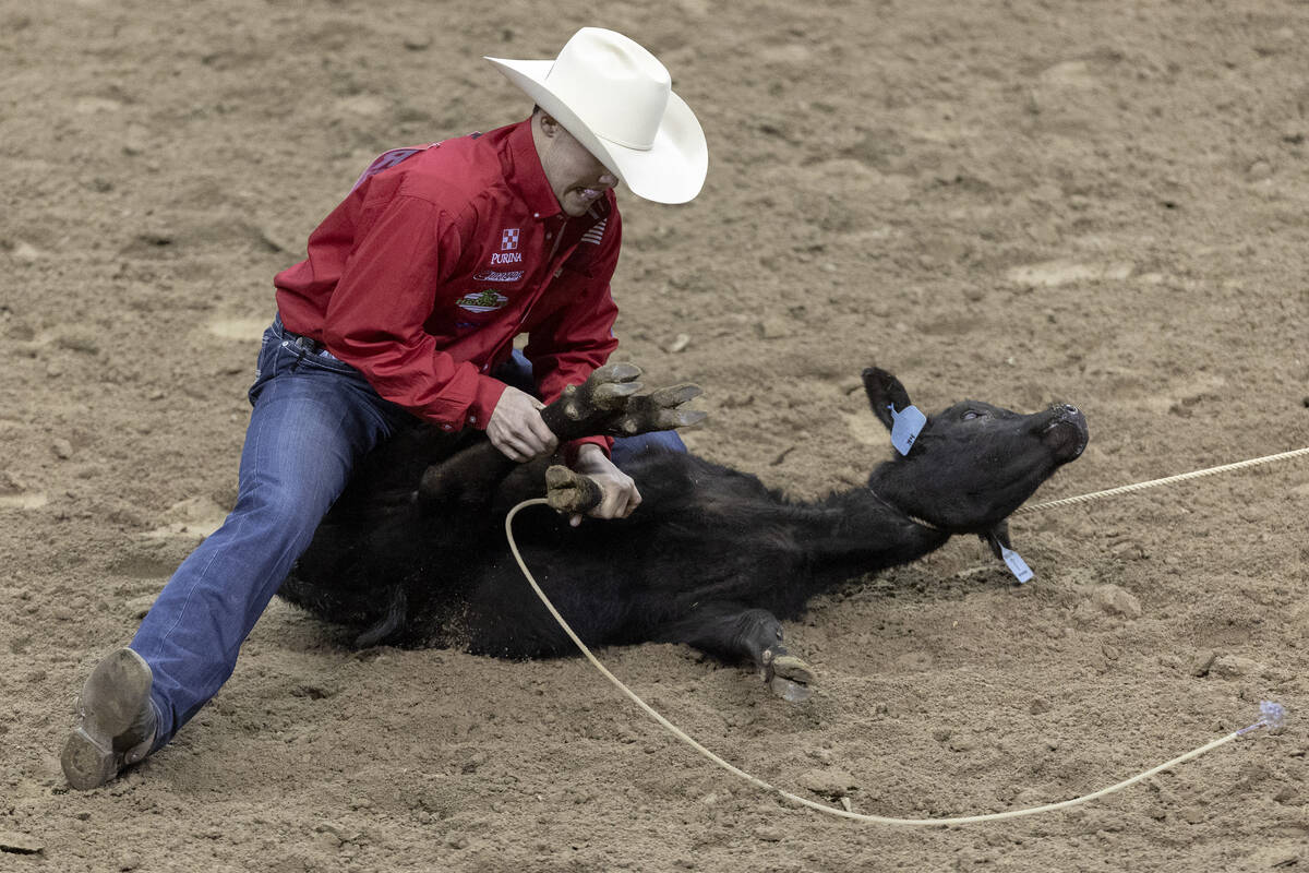 Kincade Henry, of Mount Pleasant, Tex., competes in tie-down roping during the seventh go-round ...