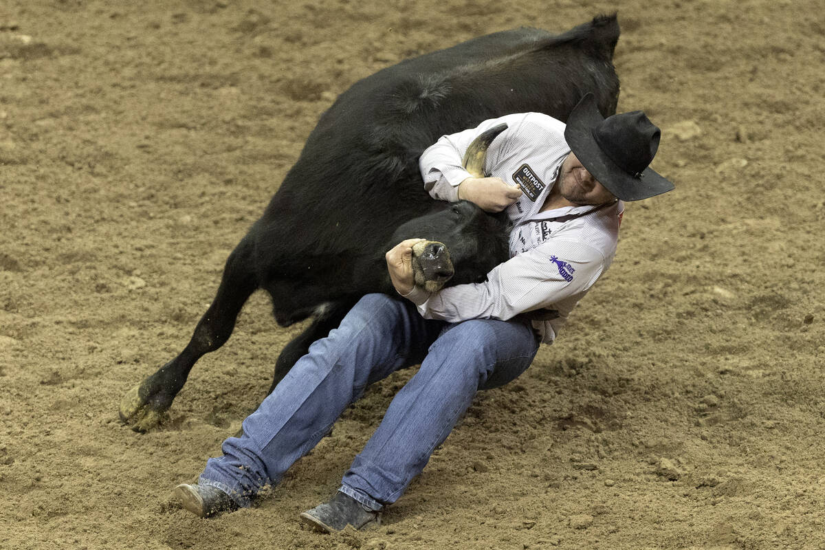 Tanner Brunner, of Ramona, Kan., competes in steer wrestling during the seventh go-round of the ...
