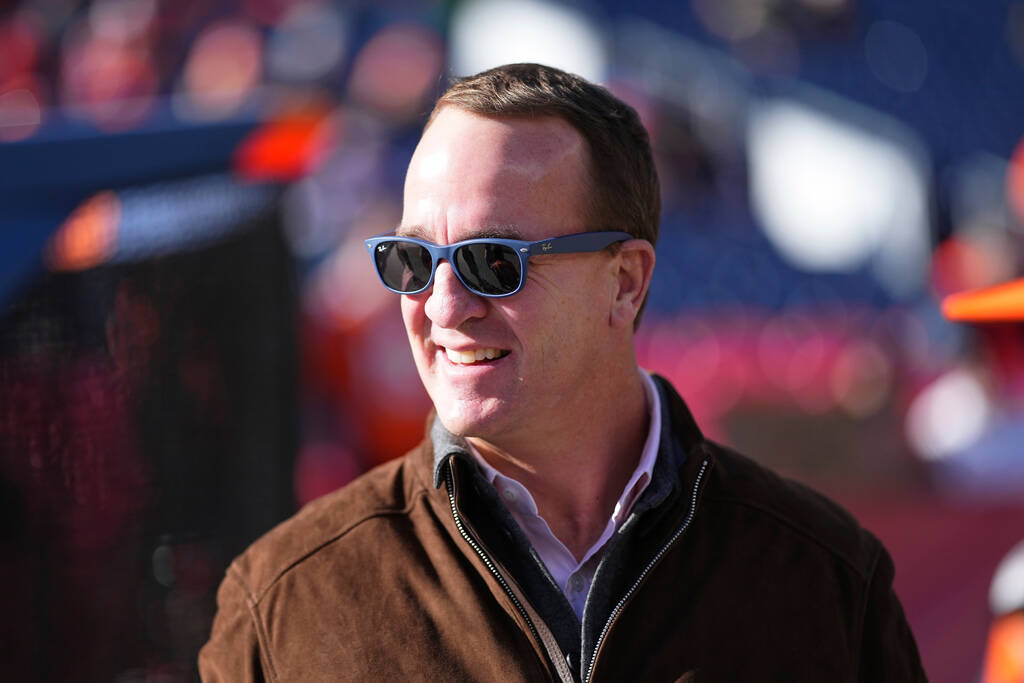 Former quarterback Peyton Manning watches players warm up before an NFL football game between t ...