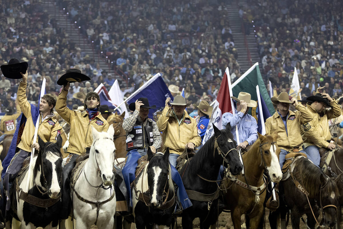 Cowboys salute the crowd with their hats before competing during the sixth go-round of the Nati ...