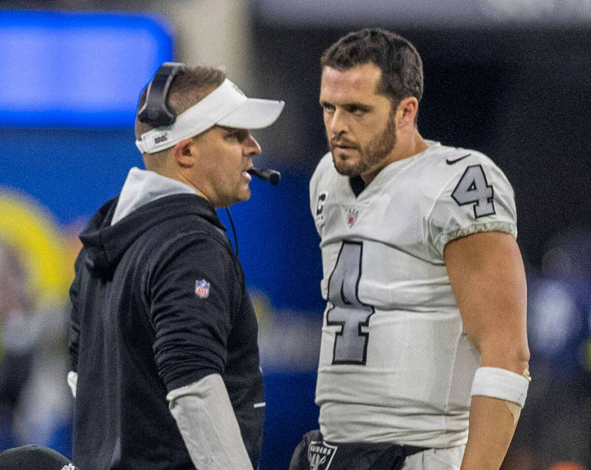 Raiders head coach Josh McDaniels speaks to Raiders quarterback Derek Carr (4) during the secon ...