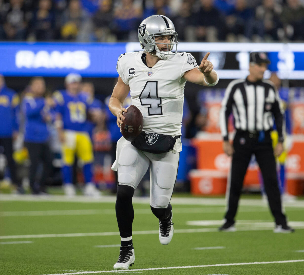 Raiders quarterback Derek Carr (4) signals as he scrambles during the first half of an NFL game ...