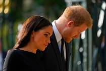 FILE - Britain's Prince Harry and Meghan, Duchess of Sussex view the floral tributes for the la ...