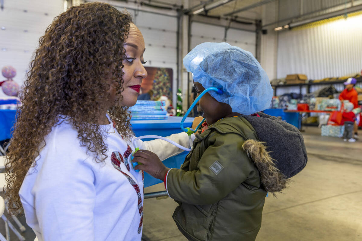 Author Elizabeth Hunterton has her heart checked by Zaire Dozier, 3, as the UMC Lions Burn Care ...