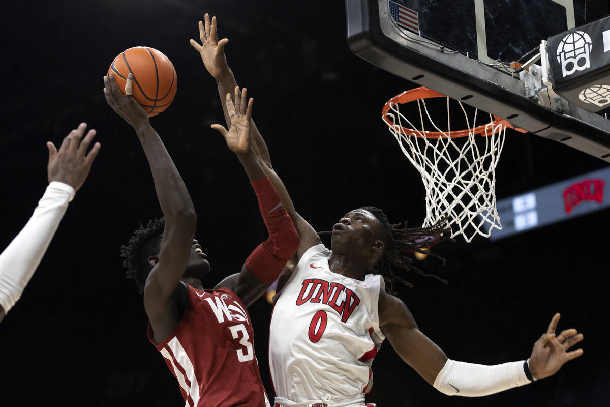 UNLV Rebels forward Victor Iwuakor (0) attempts to block a shot by Washington State Cougars for ...